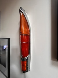 a red and orange car tail light hanging on the wall