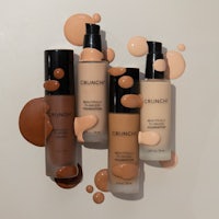 four liquid foundations on a white background