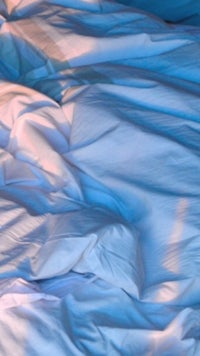 a bed with sheets and blankets on it