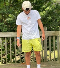 a man wearing a white t - shirt and yellow shorts