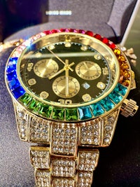 a gold watch with multi colored diamonds on it