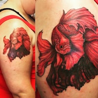 a tattoo of a red siamese fish on a woman's arm