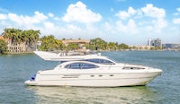 a white motor boat on the water with palm trees in the background