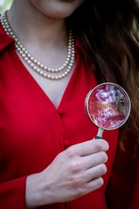 a woman holding a magnifying glass