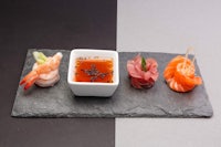 sushi and sashimi on a slate plate