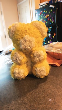 a yellow and white teddy bear sitting on a counter
