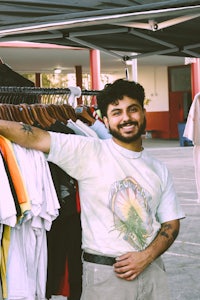 a man standing in front of a rack of shirts
