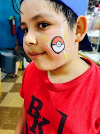 a young boy with a pokemon face painted on his face