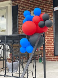 a black railing with a bunch of balloons on it