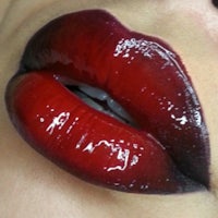 a close up of a woman's lips with red lipstick