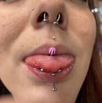 a woman with a pink piercing on her tongue