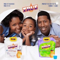 a family is laying on a bed with a bottle of baby wipes