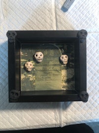 a black frame with three skulls on it