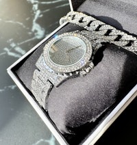 a watch with diamonds and a chain in a box