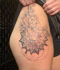a woman with a flower tattoo on her thigh
