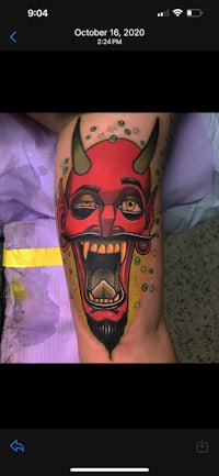 a tattoo of a devil on a person's thigh