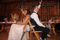 a bride and groom sitting on chairs at a wedding reception
