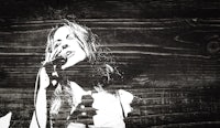 a black and white photo of a woman singing into a microphone