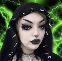 a woman wearing a black hoodie with spikes and green lightning