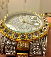 a person's wrist with a gold and diamond watch