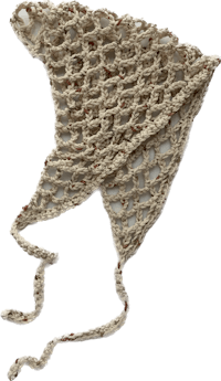 a beige crocheted hat on a black background