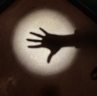 a shadow of a person's hand on a floor