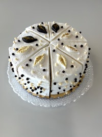 a white cake with black and gold decorations