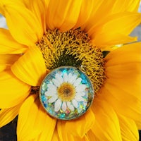 a daisy pendant is sitting on top of a sunflower