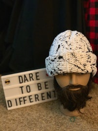 a mannequin with a beard and a sign that says dare to be different