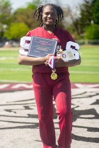 a woman in a maroon uniform holding a plaque