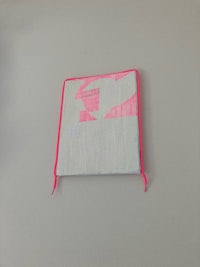 a pink and white pouch hanging on a wall