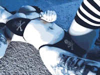 a woman in a bikini laying on the ground