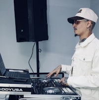 a man in a white hat is playing a dj set