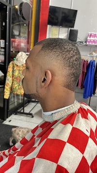 a man sitting in a barber chair with a checkered shirt