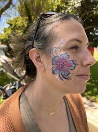 a woman with a flower painted on her face