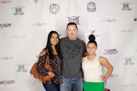 three people posing for a photo on a red carpet