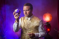 a man in a gold vest holding a magic ball