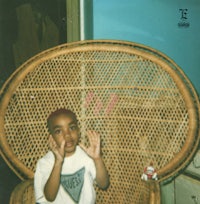 a young boy sitting in a wicker chair