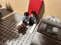 two lego policemen standing next to a door