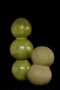 two green vases on a black background
