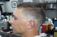 a man in a barber shop with a short haircut