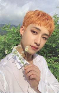 a young man with orange hair holding flowers