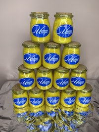 a stack of yellow jars with blue labels