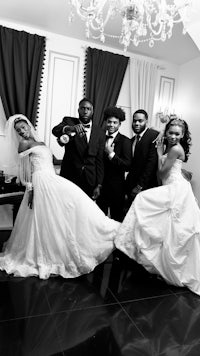 a black and white photo of a wedding party posing for a photo