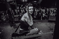 a woman playing a bass in front of a crowd