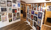 a room with many framed pictures on the wall