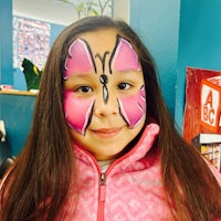 a girl with a pink butterfly painted on her face