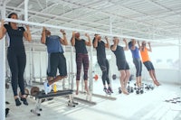 a group of people doing pull ups in a gym