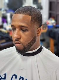 a black man in a barber shop with a beard