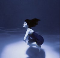 a woman in a blue dress in the water